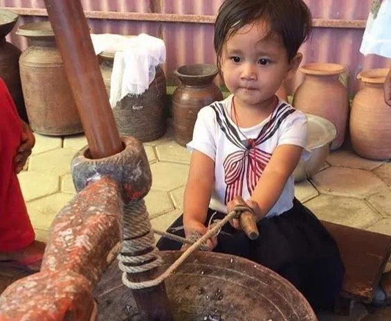 Young child exploring hands-on with rope and traditional pottery